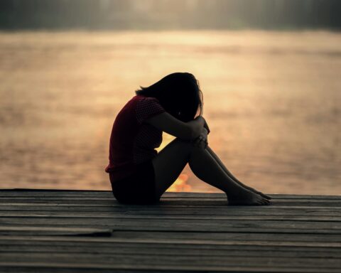 woman by lake wondering Why Do I Self-Sabotage Even When Things Are Going Well