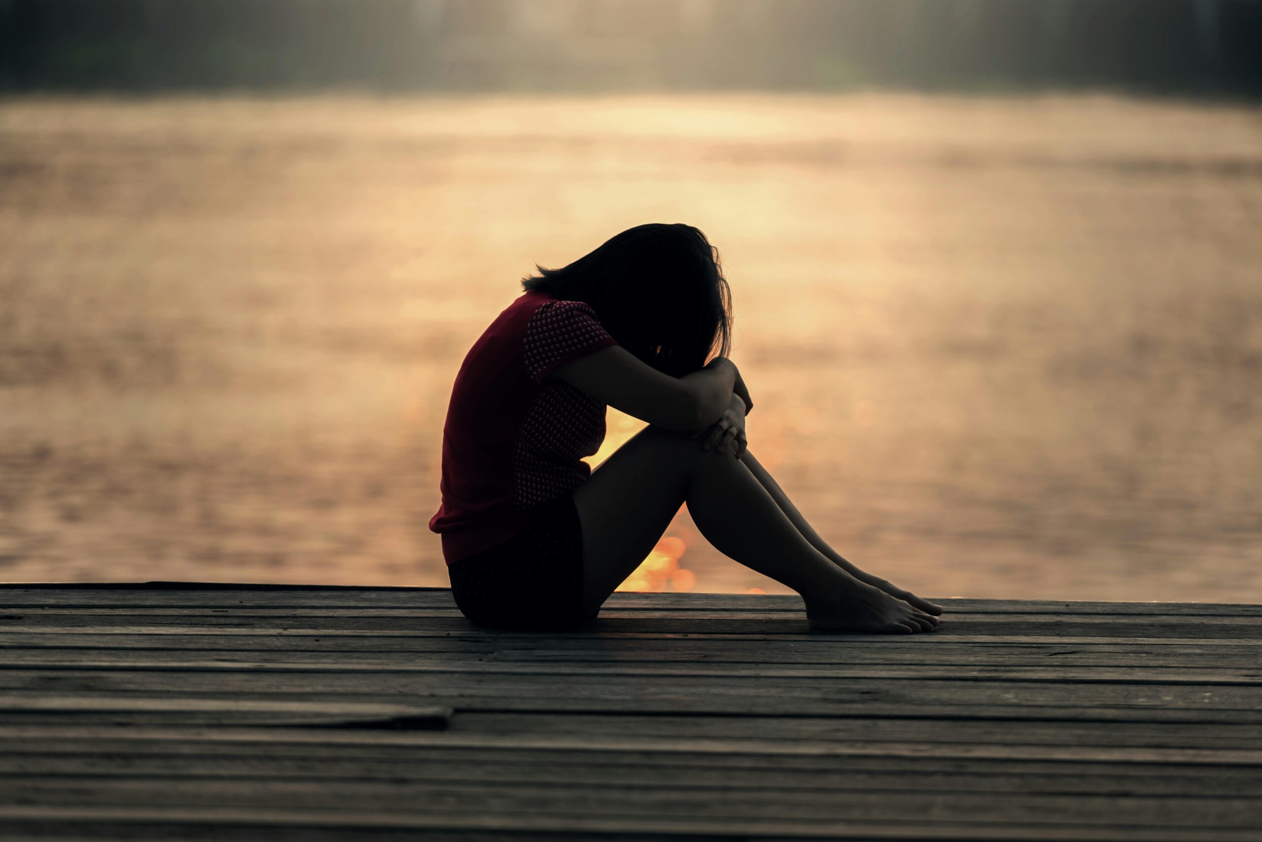 woman by lake wondering Why Do I Self-Sabotage Even When Things Are Going Well