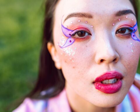 trans women butterfly makeup photoshoot in grass